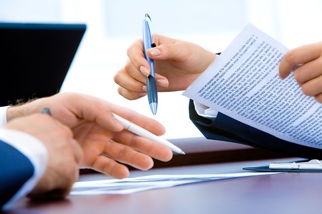 Two People Signing A Contract