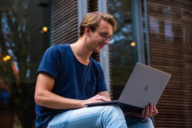 Man Smiling Holding Laptop