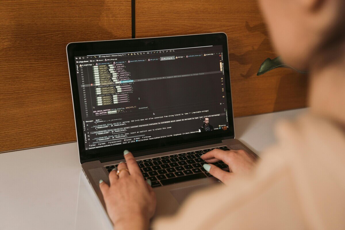 A woman coding on her computer after taking an information security qualification.